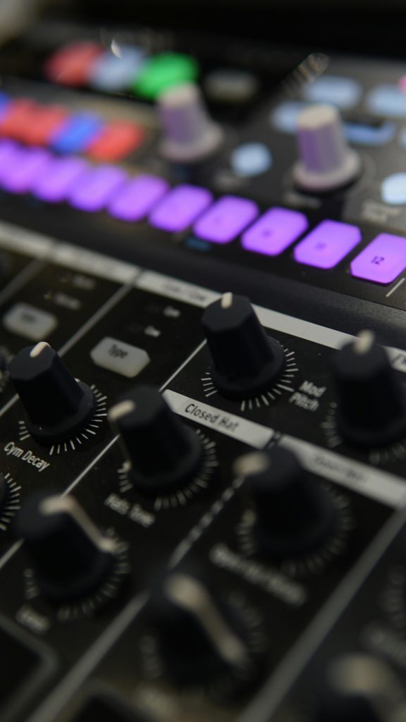 Detailed close-up of an audio mixer with illuminated colorful control buttons.